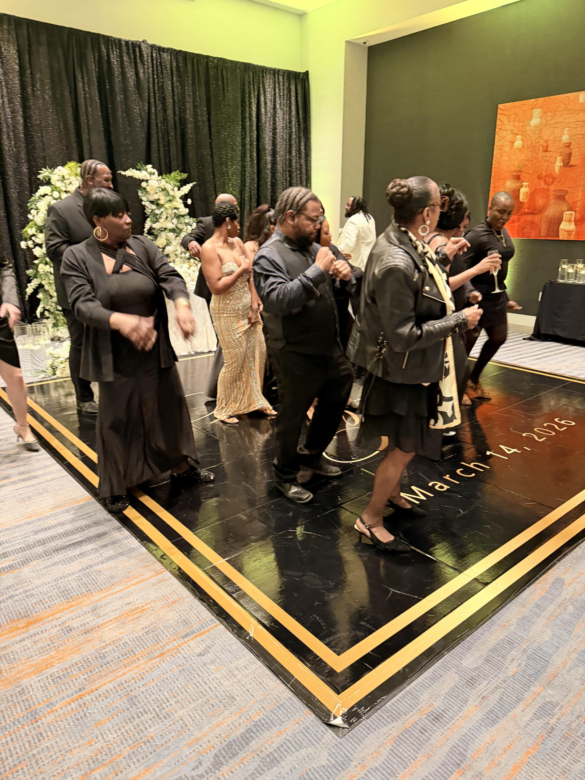 A group of people dancing on a stage at a formal event.